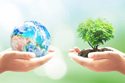 Two children hold a small globe and a small tree.